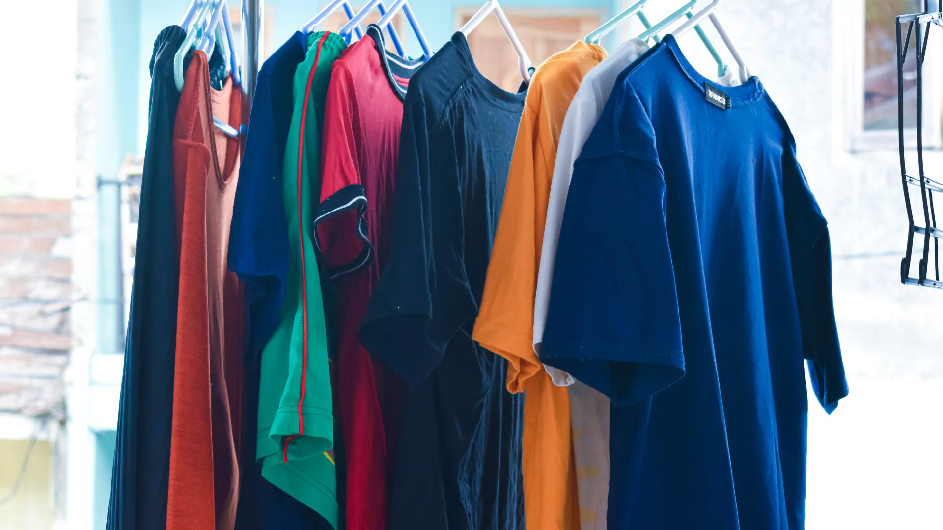 t-shirts drying on coat hangers