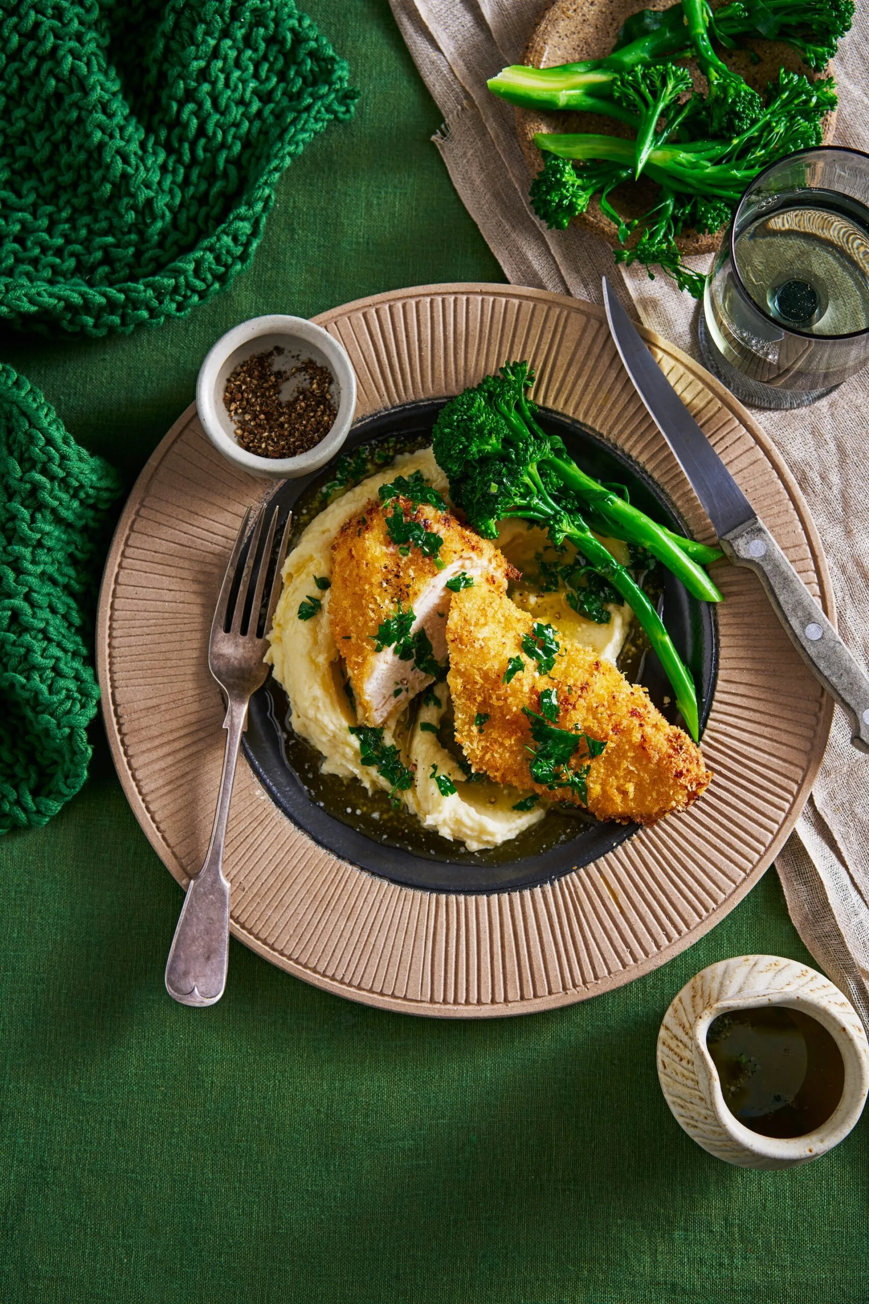 air fryer chicken kiev in brown bowl on blob of mashed potato with broccolini on the side