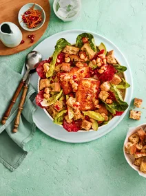 orange and haloumi salad in white bowl with pomegranate seeds and cos lettuce