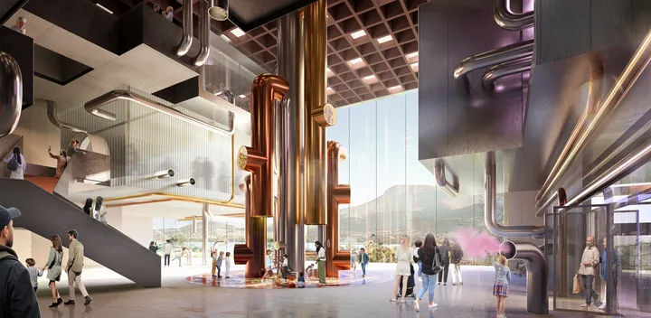 chocolate experience at cadbury with big gold pipes in the middle of the room with children playing and purple carpet
