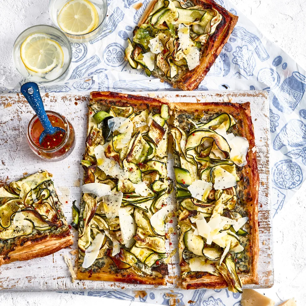 zucchini and ricotta tart on chopping board with extra slice on the side