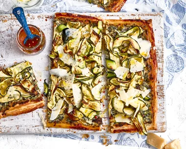 zucchini and ricotta tart on chopping board with extra slice on the side