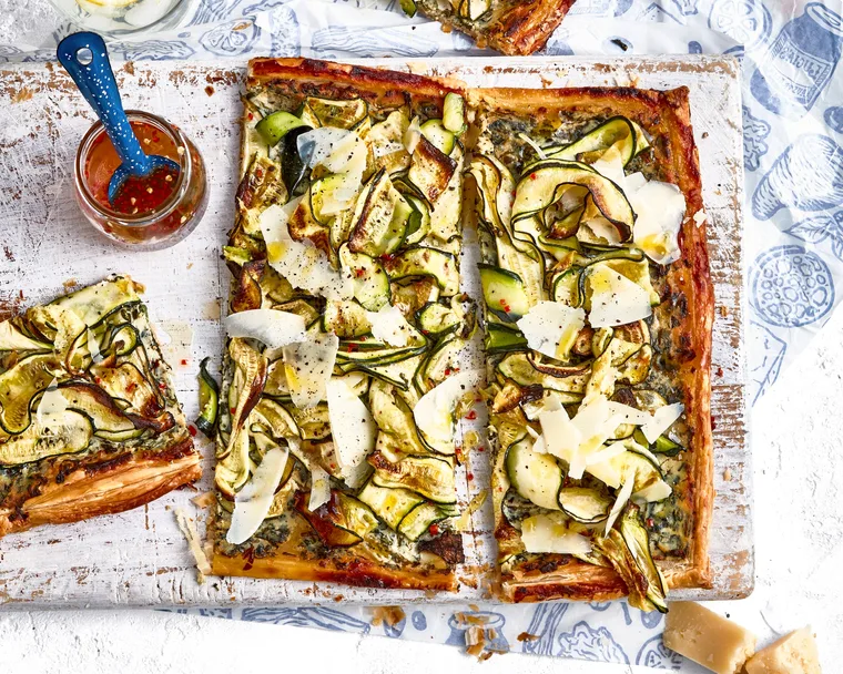 zucchini and ricotta tart on chopping board with extra slice on the side