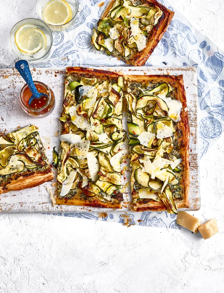 zucchini and ricotta tart on chopping board with extra slice on the side