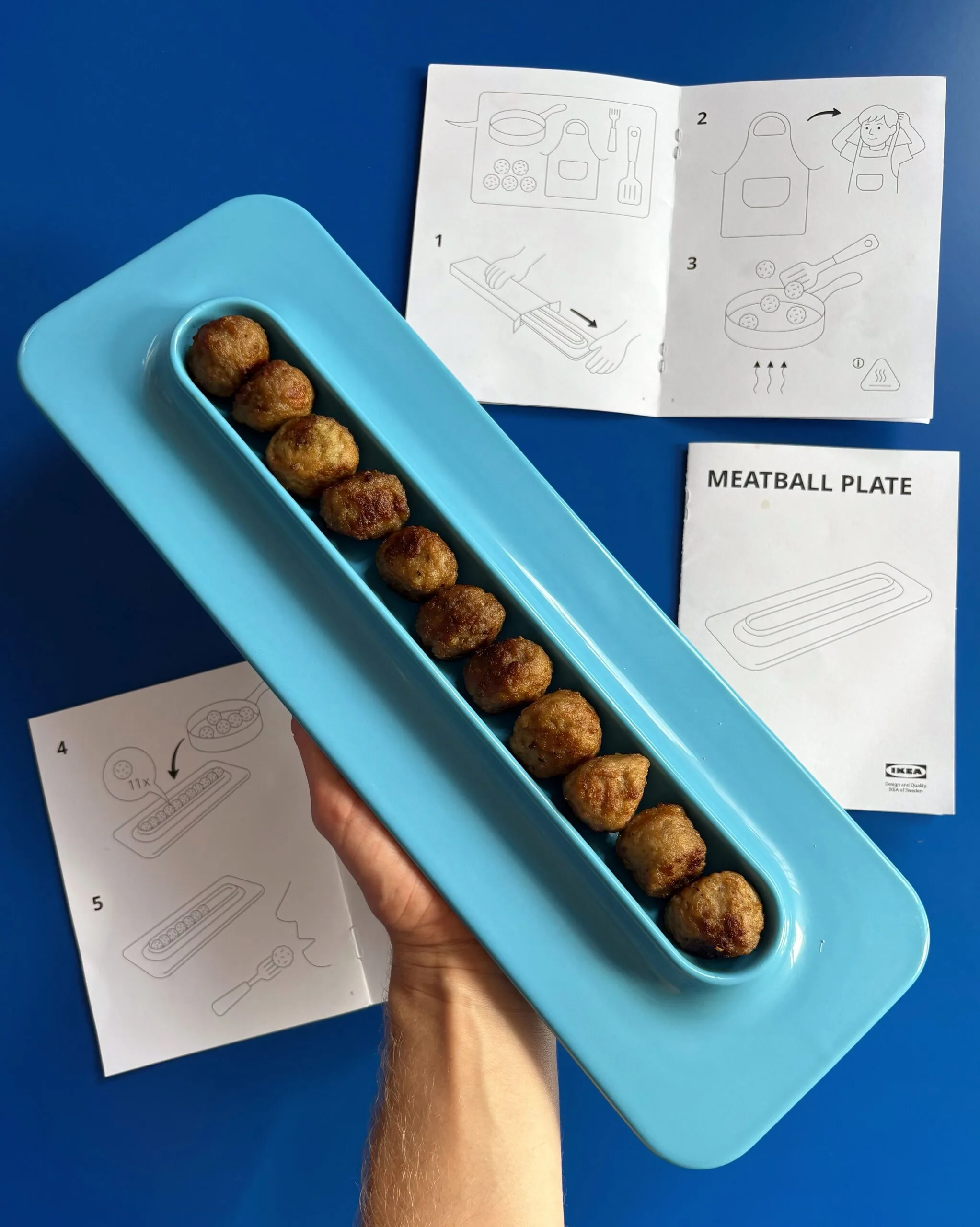 ikea meatball tray in bright blue with meatballs lined up in it