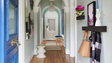 Blue front door opening onto a long hallway