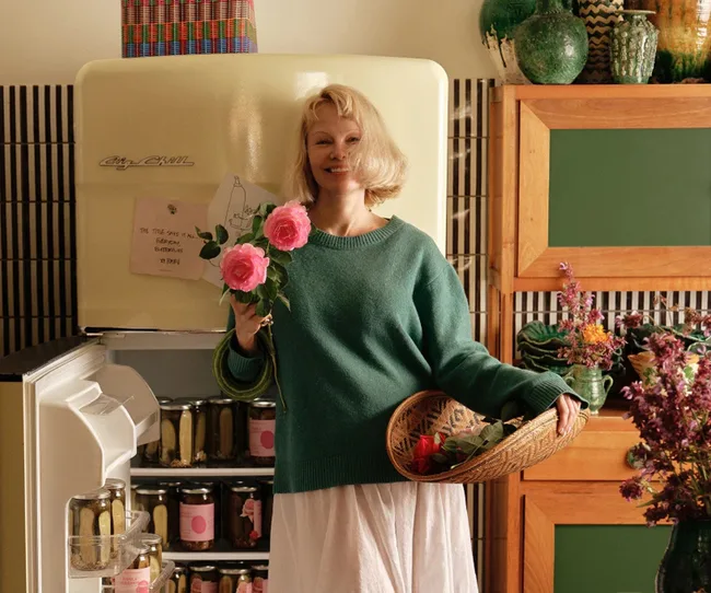 pamela anderson in front of fridge filled with picke jars