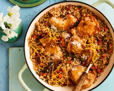 pearl barley risotto with chicken in large pot with handles and wooden spoon sticking out
