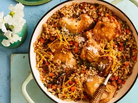 pearl barley risotto with chicken in large pot with handles and wooden spoon sticking out