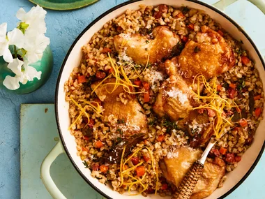 pearl barley risotto with chicken in large pot with handles and wooden spoon sticking out