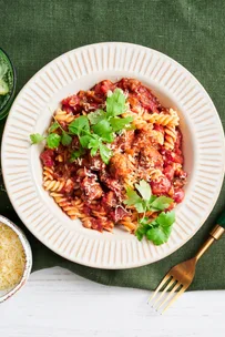 pork and fennel meatball pasta with parsley and parmesan on top in white bowl