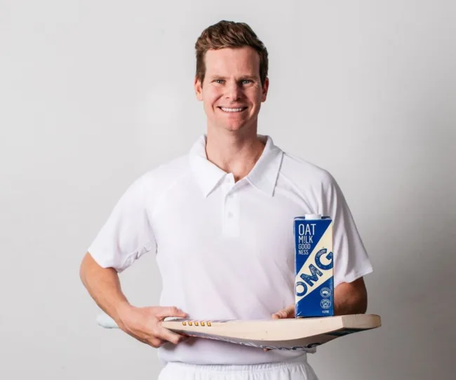 steve smith holding cricket bat and omg oat milk