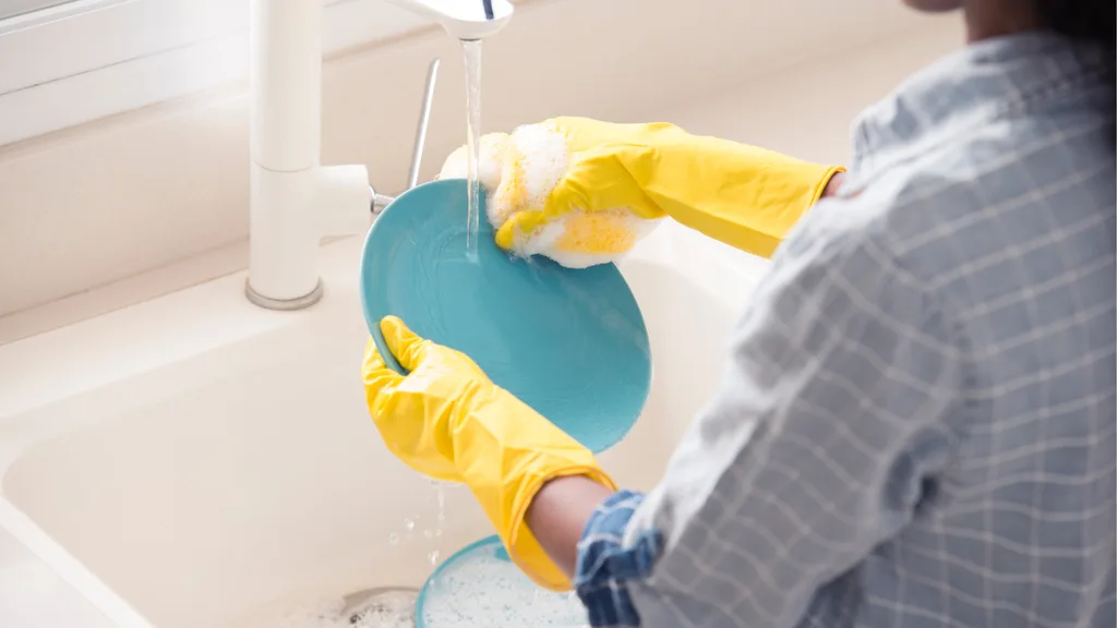 washing a blue plate in the sink with a bar of soap