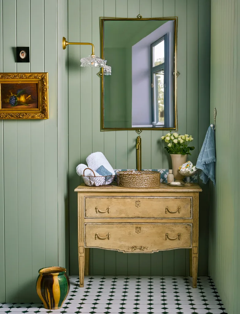 vintage decor for modern home with wooden commode, white rosebuds and antique decor in sage green bathroom