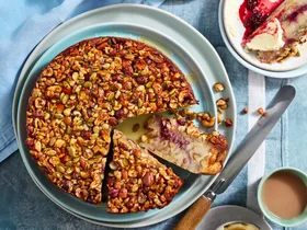 bread and butter cake recipe with cake covered in nuts and seeds with two slices cut to show cross section