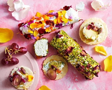 goats cheese logs with edible flowers and pistachios pressed into the outside