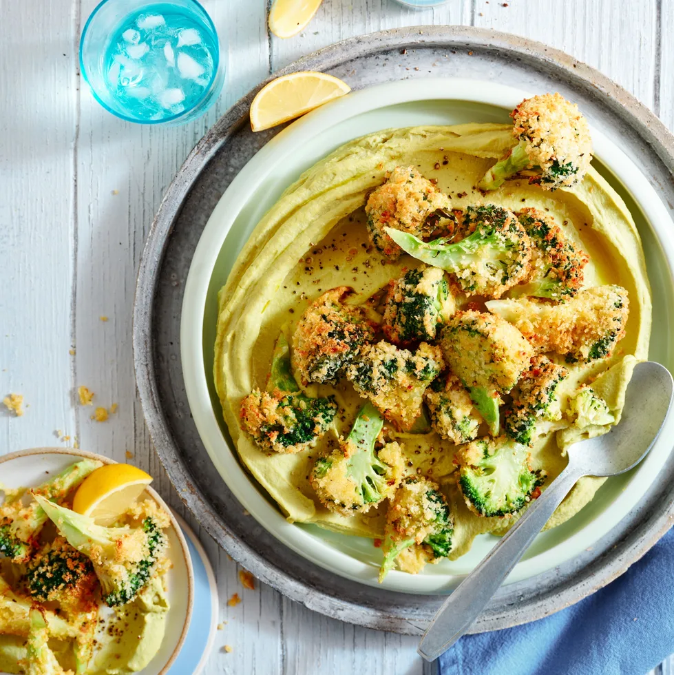 A homemade hummus with crispy broccoli on top.