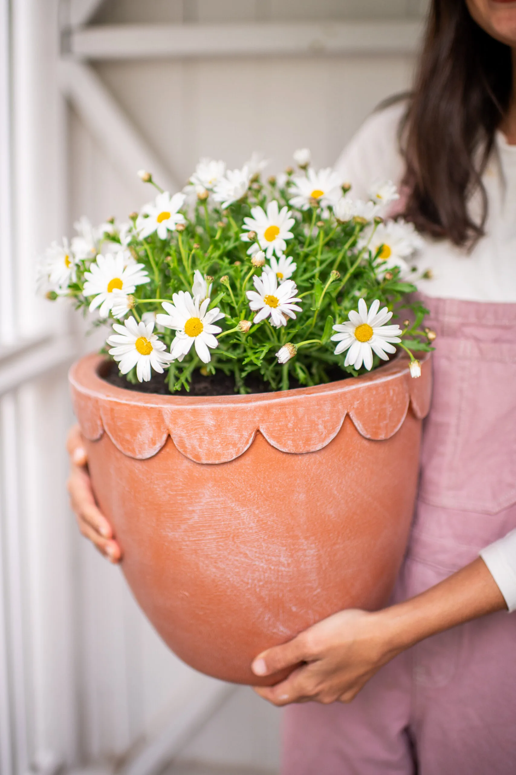 Geneva Vanderzeil holding a DIY scalloped terracotta pot