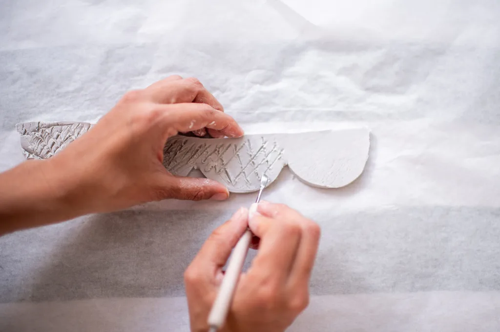 pontuação sendo feita em argila recortada e seca ao ar