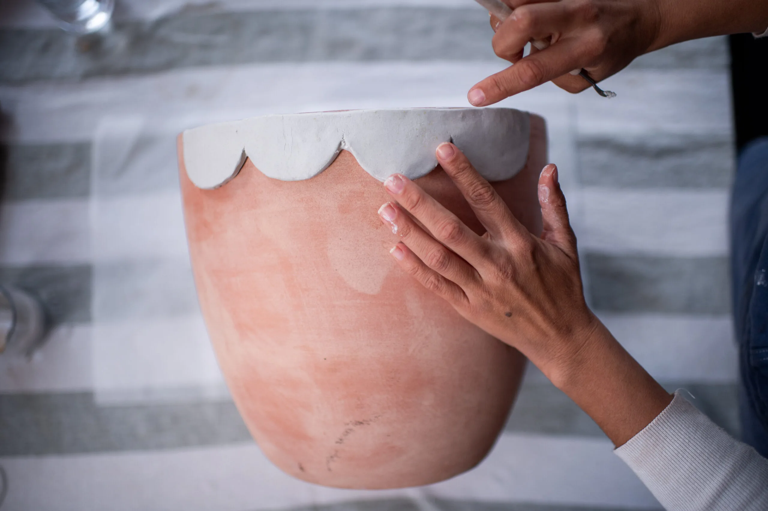 borda recortada sendo pressionada em um vaso de terracota 