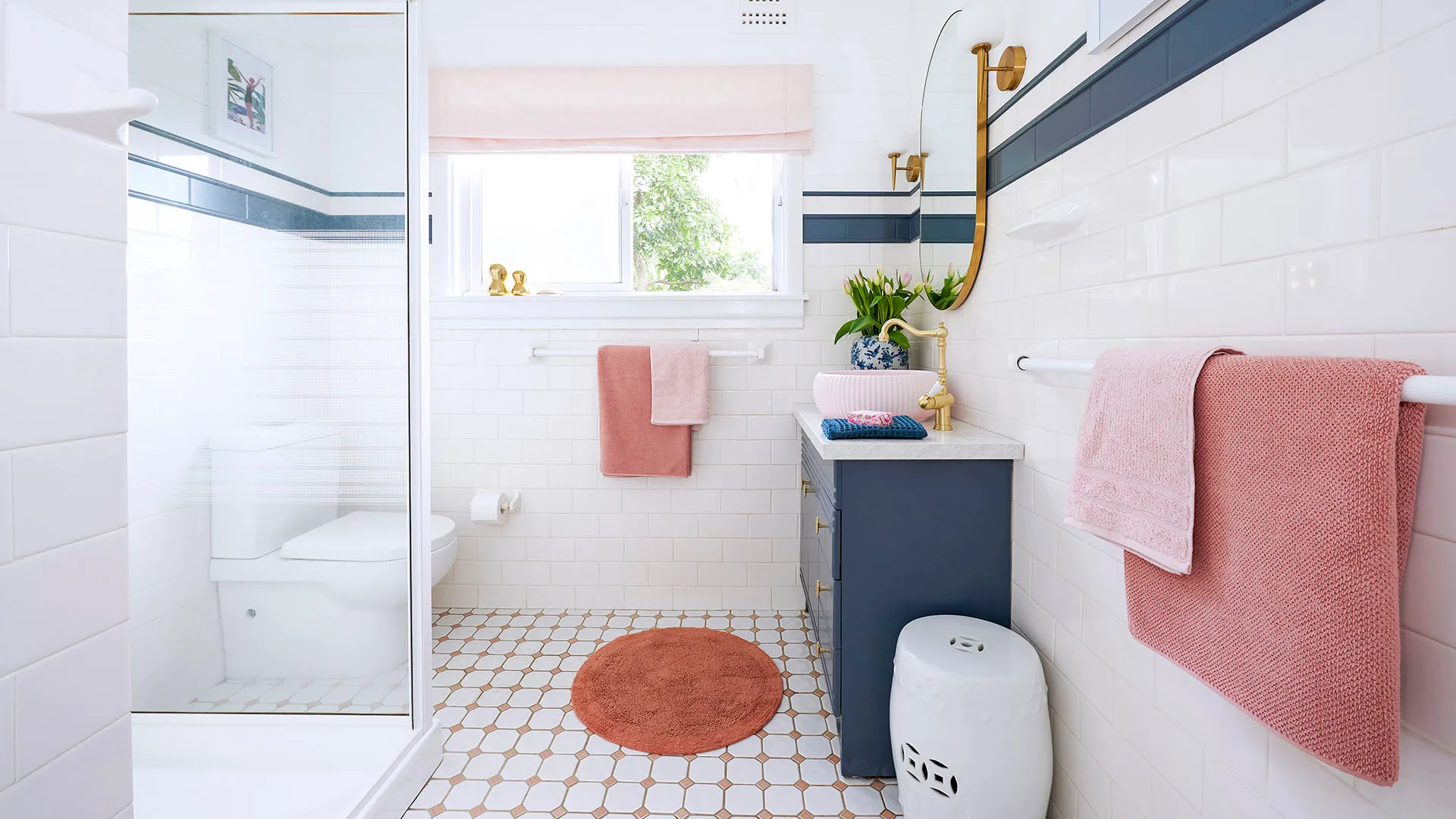 Cosmetically renovated bathroom with navy accents and white shower base.