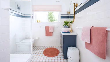 Cosmetically renovated bathroom with navy accents and white shower base.