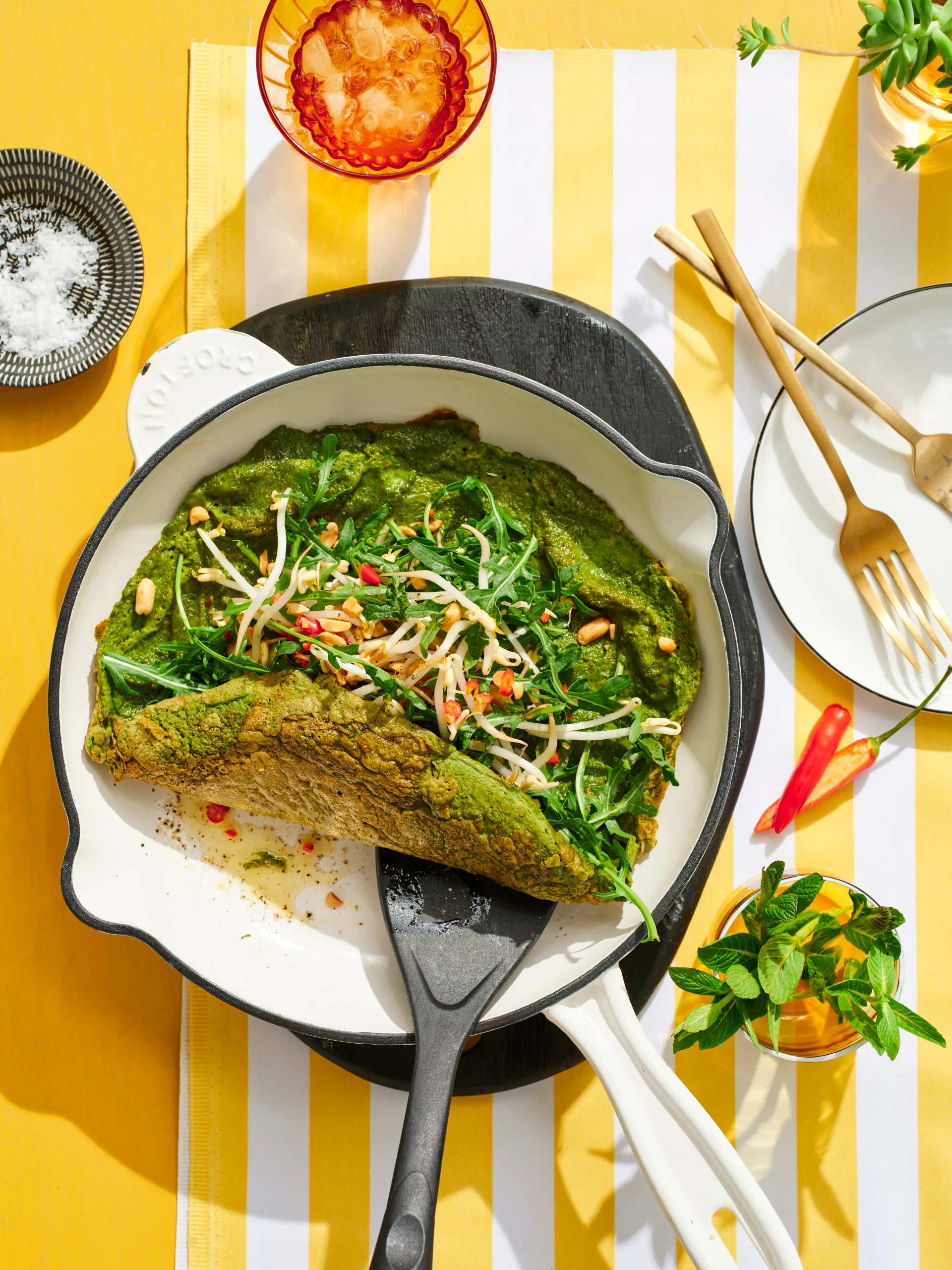 spiced green eggs omelette in pan with spatula pushing it up