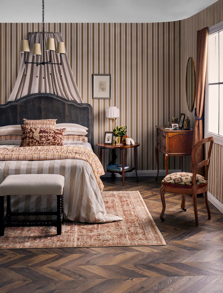 vintage home styling with stripy wallpaper antique looking bedhead and frame with custom antique teak chairs and embroidered pillows