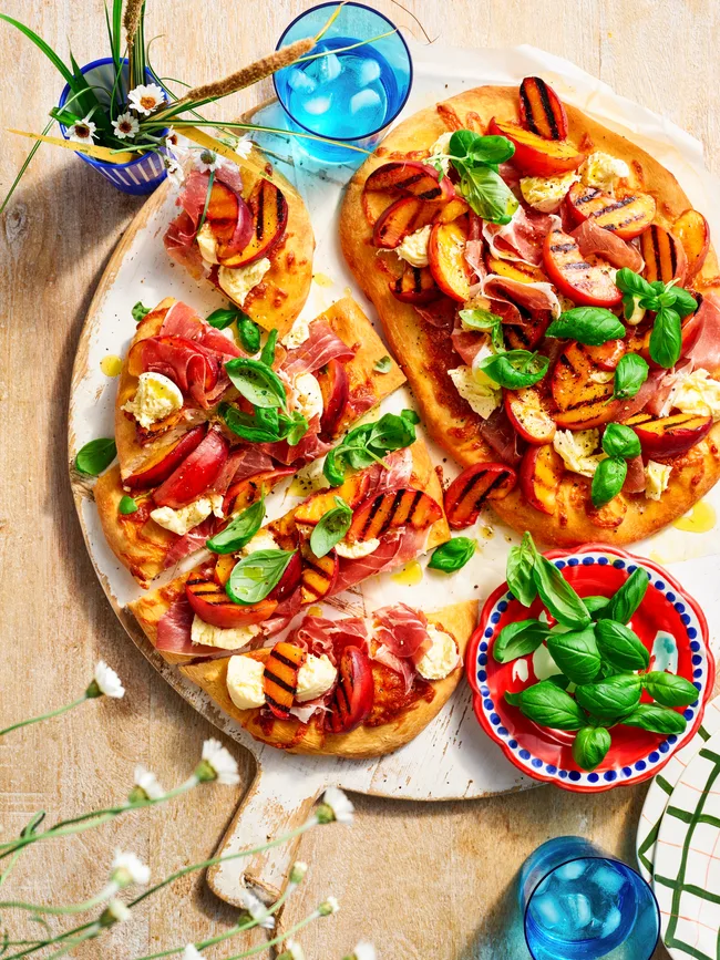 Barbecued flatbread with peach, prosciutto and bocconcini and basil on top