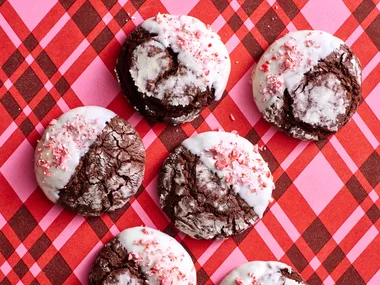 chocolate crinkle cookies with crushed candy cane topping on stripy pink tartan background