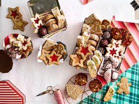 christmas baking with lots of biscuits piled in different box containers