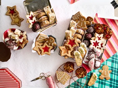 christmas baking with lots of biscuits piled in different box containers