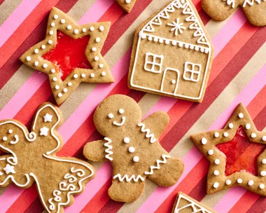 gingerbread recipe with gingerbread men stars with lolly centre and gingerbread 2D houses on stripy pink and red tablecloth