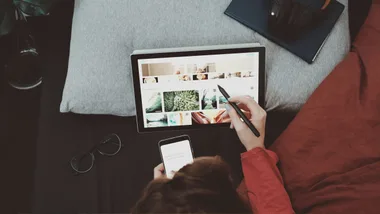 Lenovo promo code: overhead image of a person using a tablet and stylus or pen.