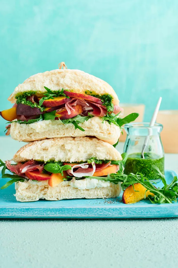 Peach, proscuitto and pesto sandwich on a blue tray