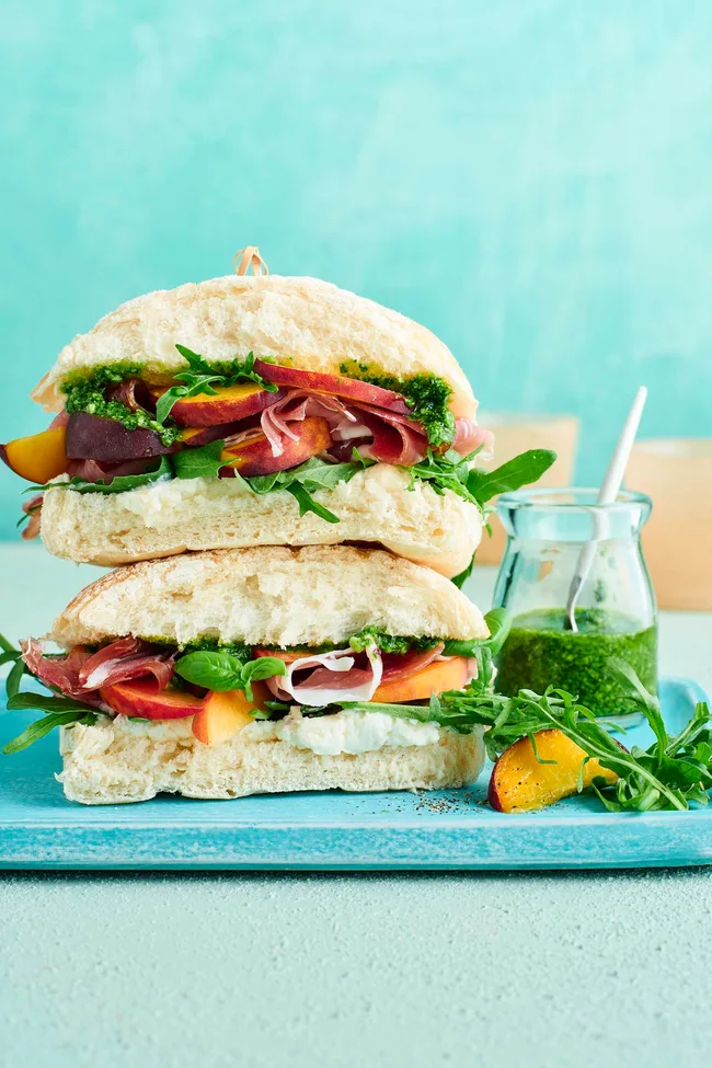 Peach, proscuitto and pesto sandwich on a blue tray