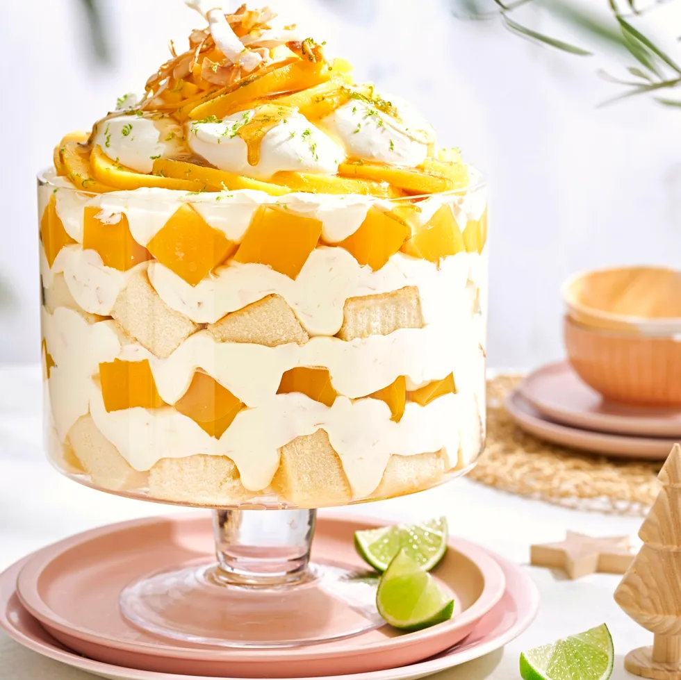 mango trifle filled with homemade mango jelly, coconut cream, linme and piled high above the trifle dish