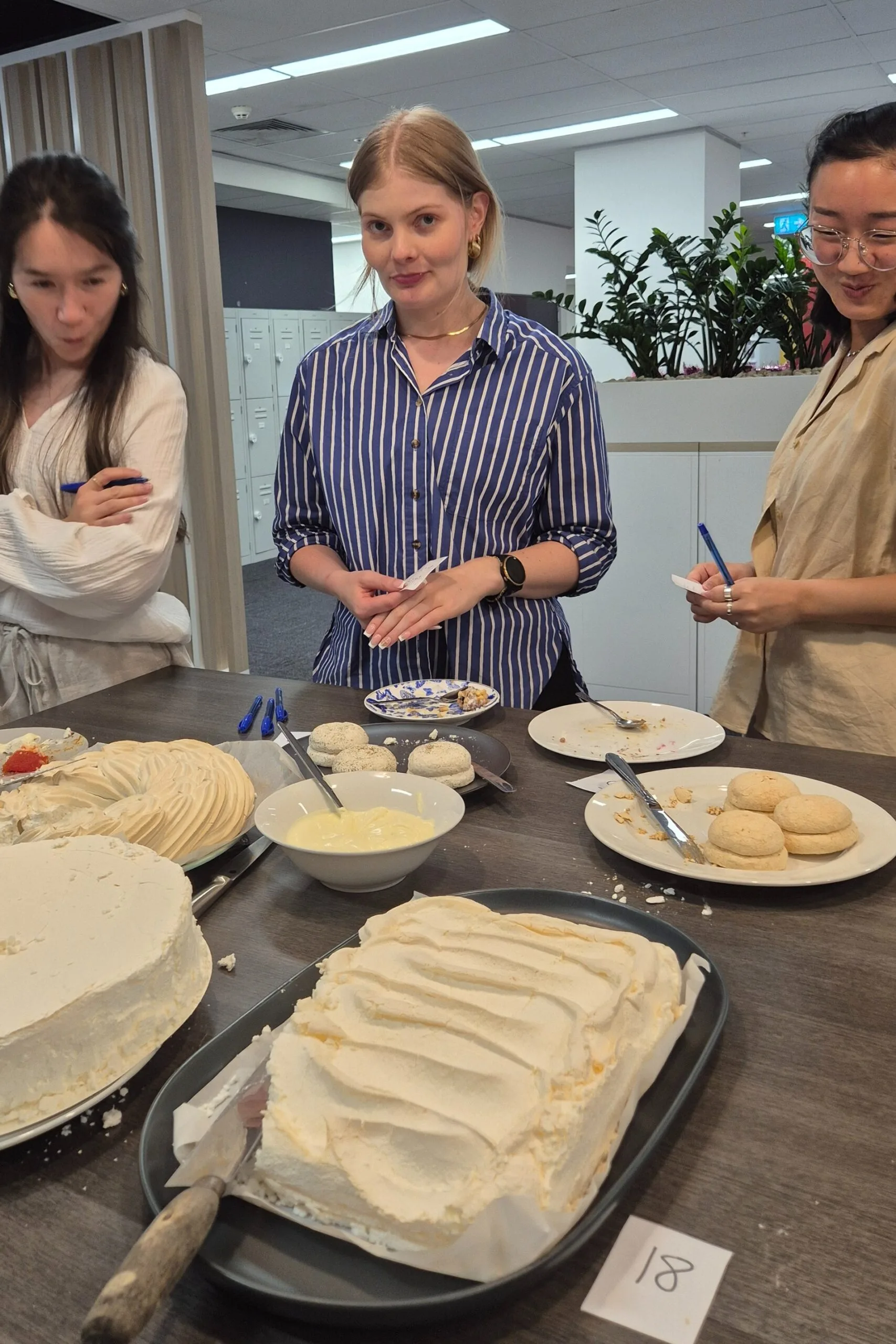 Three women blind taste-testing pavlovas from Australian supermarkets for Christmas. Pavlovas are from Woolworths, ALDI and Coles.