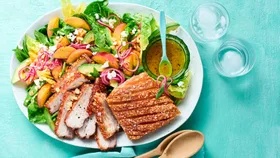 Airfryer pork belly and peach salad with ice water and wooden serving spoons