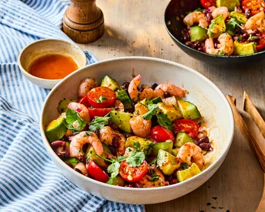 prawn and black bean salad in bowl with pepper shaker behind it