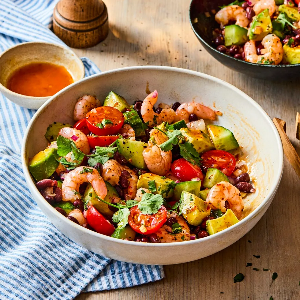 prawn and black bean salad in bowl with pepper shaker behind it