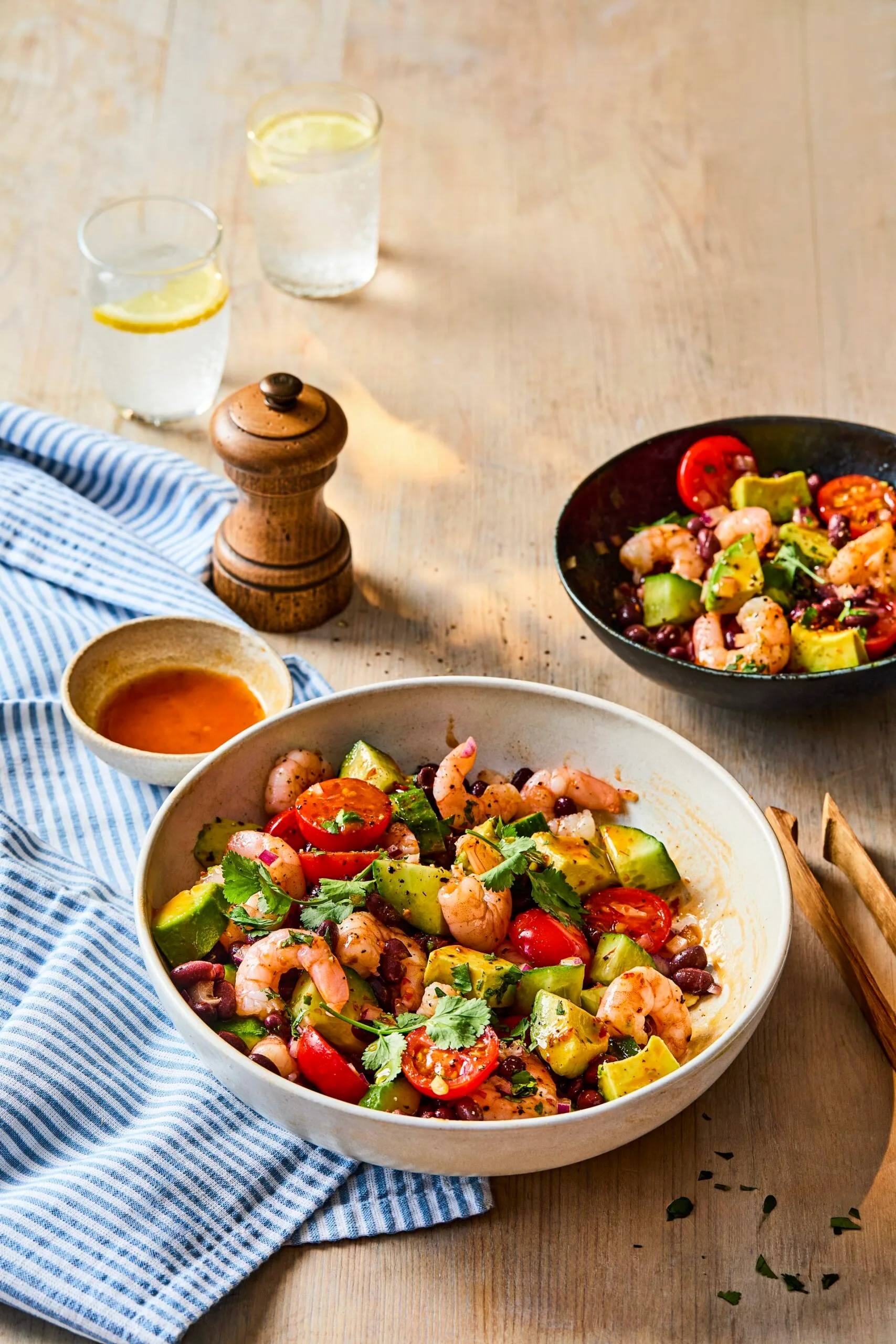 prawn and black bean salad in bowl with pepper shaker behind it