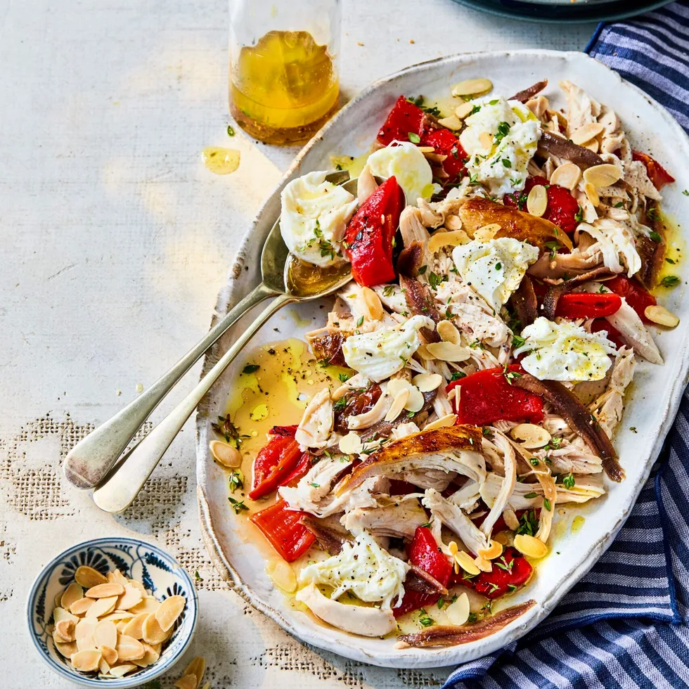 chicken capsicum salad with anchovies and bread in long oval bowl