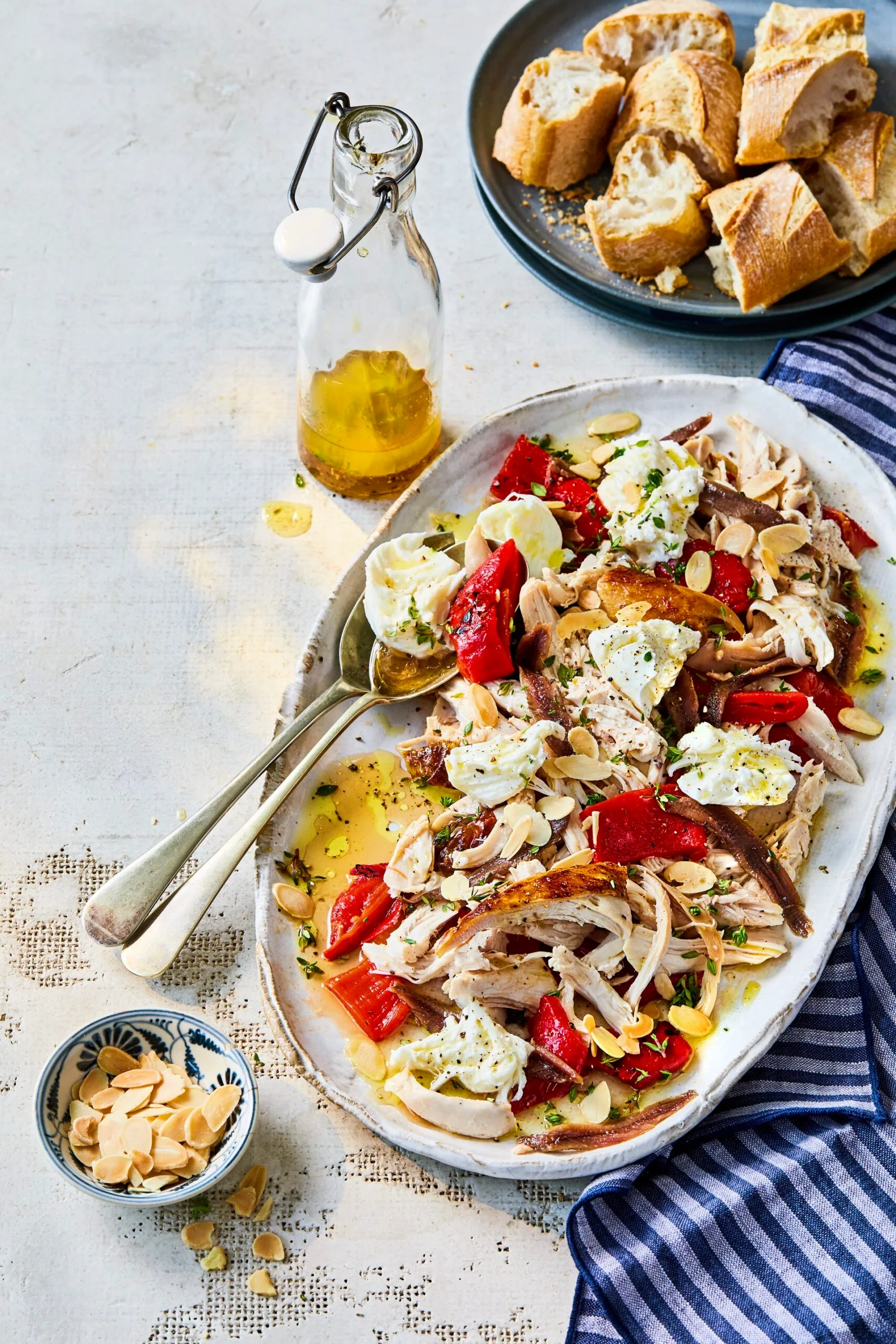 chicken capsicum salad with anchovies and bread in long oval bowl
