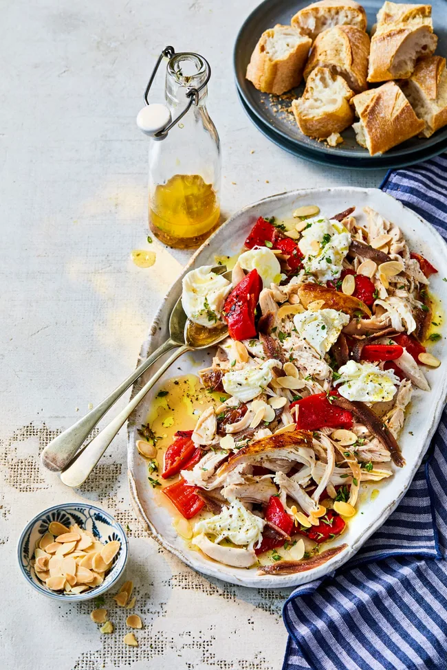 chicken capsicum salad with anchovies and bread in long oval bowl