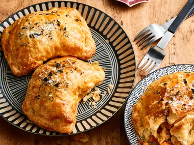 chicken and vegetable pasties with nigella seeds on top on round plates