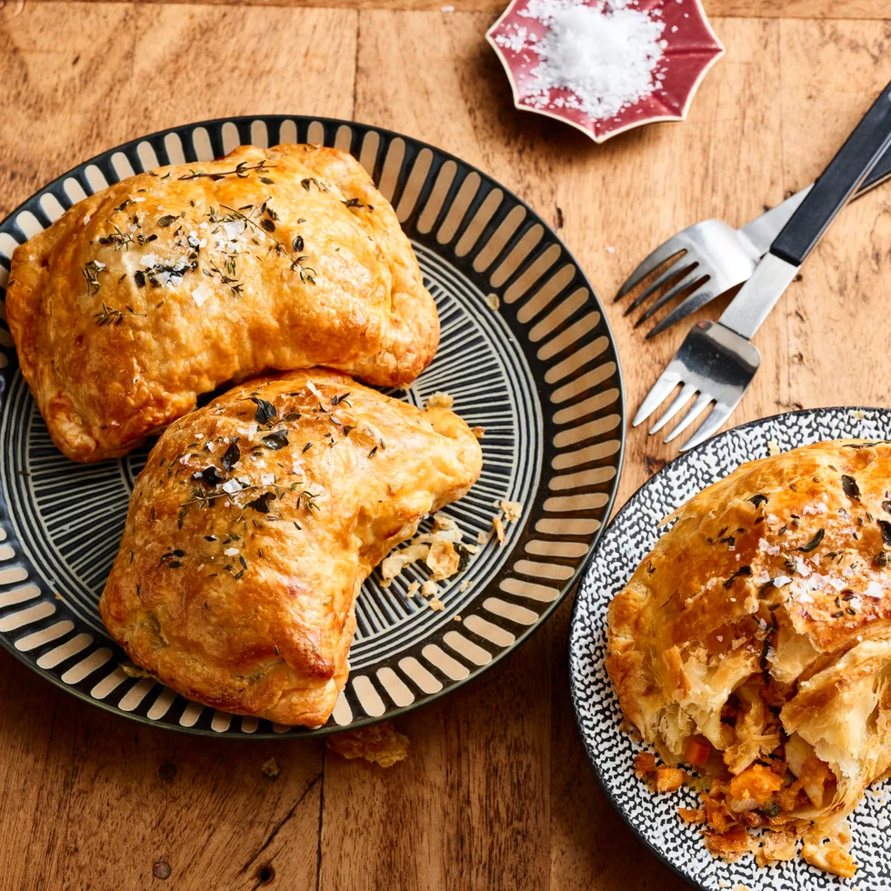 chicken and vegetable pasties with nigella seeds on top on round plates