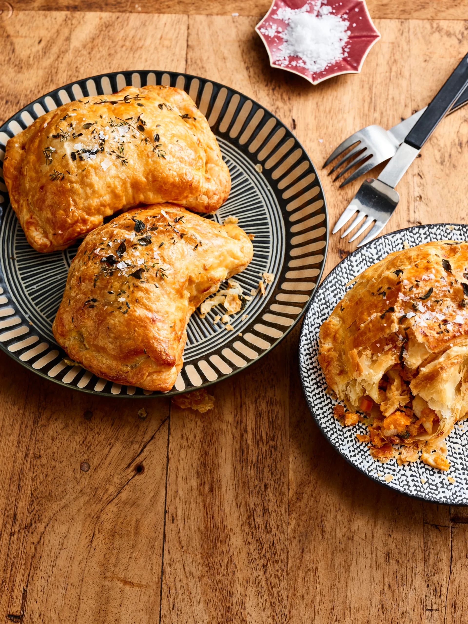 chicken and vegetable pasties with nigella seeds on top on round plates