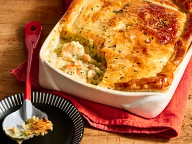 colins fish pie in rounded rectangular dish with one spoon taken out