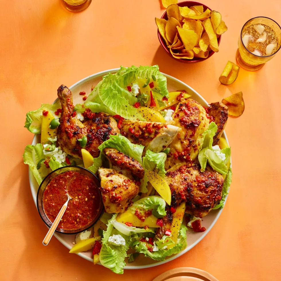 barbecue chilli chicken in with mango and lettuce salad in bowl, with sweet potato crisps on the side